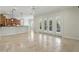 Open-concept living area featuring travertine floors, neutral paint and large French doors with plantation shutters at 123 Tangelo Court, Maitland, FL 32751