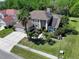 A captivating aerial shot showcasing a two-story home with solar panels nestled amidst mature trees and a manicured lawn at 12618 Greco Dr, Orlando, FL 32824
