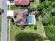 Birds-eye view of beautiful pool home with brown roof and solar panels in a neighborhood with a pond at 12618 Greco Dr, Orlando, FL 32824