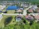 Overhead view of a neighborhood featuring a pool home with solar panels, set amongst a community with ponds at 12618 Greco Dr, Orlando, FL 32824
