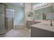 Primary bathroom with quartz counters, double sinks, large mirror, soaking tub, and glass shower at 12618 Greco Dr, Orlando, FL 32824