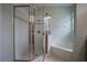 Elegant bathroom featuring a glass enclosed shower with tile surround and separate garden tub at 12618 Greco Dr, Orlando, FL 32824
