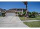 Attractive two-story home featuring a well-manicured lawn, a spacious three-car garage, and classic architectural details at 12618 Greco Dr, Orlando, FL 32824
