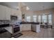 Bright kitchen featuring white cabinetry, stainless steel appliances, and a dining area with large windows at 12618 Greco Dr, Orlando, FL 32824