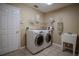 Spacious laundry room featuring modern washer and dryer, storage shelves, and utility sink at 12618 Greco Dr, Orlando, FL 32824