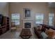 Living room featuring a fireplace, pool views, a zebra artwork, and wood-look flooring at 12618 Greco Dr, Orlando, FL 32824