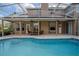 Relaxing screened-in pool area with covered patio, dining set, and views of the home's exterior at 12618 Greco Dr, Orlando, FL 32824