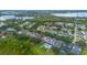 This aerial view shows homes with pools and well-maintained lawns in a neighborhood by a lake, highlighting community living at 14231 Sonco Ave, Windermere, FL 34786
