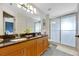 Bathroom featuring double sinks, granite countertops, and a glass shower at 14231 Sonco Ave, Windermere, FL 34786