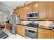 Well-equipped kitchen boasts stainless steel appliances and wood cabinetry offering storage and functionality at 14231 Sonco Ave, Windermere, FL 34786
