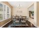 Inviting dining space with wood floors, a modern chandelier, and a view into the cozy living room area at 1428 Lucky Pennie Way, Apopka, FL 32712