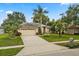 Welcoming single-Gathering home with a well-maintained yard and a long driveway leading to an attached two-car garage at 1428 Lucky Pennie Way, Apopka, FL 32712