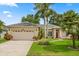 Charming single-story home with a lush lawn, mature palm trees, and a welcoming red front door at 1428 Lucky Pennie Way, Apopka, FL 32712