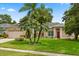Charming single-story home with well-manicured lawn and lush tropical landscaping, including palm trees at 1428 Lucky Pennie Way, Apopka, FL 32712