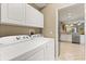 Well-equipped laundry room with modern appliances and ample storage, connected to the kitchen area for convenience at 1428 Lucky Pennie Way, Apopka, FL 32712