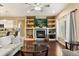 Bright living room with a cozy fireplace, built-in shelving, and an adjacent kitchen with bar seating at 1428 Lucky Pennie Way, Apopka, FL 32712