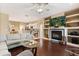 Inviting living room with built-in shelving surrounding a fireplace, seamlessly connected to the open kitchen area at 1428 Lucky Pennie Way, Apopka, FL 32712