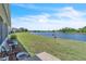 Expansive waterfront backyard with a bench, offering tranquil lake views and lush green space at 14650 Laguna Beach Cir, Orlando, FL 32824