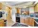 Bright kitchen with granite counters, wood cabinets, black appliances and views to living spaces at 14650 Laguna Beach Cir, Orlando, FL 32824