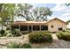 Charming backyard view, landscaped with lush bushes, a screened porch and lovely trees at 1575 N Ridge Lake Cir, Longwood, FL 32750