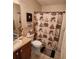 A nautical themed bathroom with a vanity sink, toilet, framed starfish and decorative shower curtain at 16922 Se 81St Charlesfort Ave, The Villages, FL 32162
