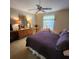 A comfortably furnished bedroom with a purple quilt, ceiling fan, and a dresser with ornate mirror at 16922 Se 81St Charlesfort Ave, The Villages, FL 32162