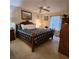 A cozy bedroom featuring a wooden bed frame, ceiling fan, and view of the window and bedside table at 16922 Se 81St Charlesfort Ave, The Villages, FL 32162
