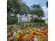 Merry Oak Villas entrance sign surrounded by colorful flowers and green landscaping on a sunny day at 16922 Se 81St Charlesfort Ave, The Villages, FL 32162