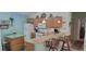 A cozy kitchen featuring wooden cabinetry, a breakfast bar with seating, and essential appliances at 16922 Se 81St Charlesfort Ave, The Villages, FL 32162
