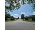 Street view of Merry Oak Villas entrance signs, mature trees, and landscaping welcoming residents and visitors at 16922 Se 81St Charlesfort Ave, The Villages, FL 32162