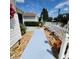 Landscaped walkway with vibrant plants and white picket fence leading to the home's entrance at 16922 Se 81St Charlesfort Ave, The Villages, FL 32162