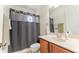 Clean bathroom featuring a vanity sink, toilet, and shower with a unique circular window at 1778 Waterside Oaks Dr, Orange City, FL 32763