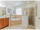 Bathroom with a tub, glass block window and glass-enclosed shower at 1778 Waterside Oaks Dr, Orange City, FL 32763