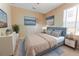 Well-lit bedroom featuring a cozy bed with blue accents and stylish artwork at 1778 Waterside Oaks Dr, Orange City, FL 32763