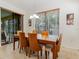 Bright dining room featuring a wooden table, six chairs, and large windows with wood blinds at 1778 Waterside Oaks Dr, Orange City, FL 32763