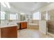 Spacious main bathroom with dual sinks, tub, glass block window, and a tiled walk-in shower at 1778 Waterside Oaks Dr, Orange City, FL 32763