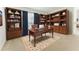 Office with built in wood bookcases and desk highlighted by a patterned area rug at 1778 Waterside Oaks Dr, Orange City, FL 32763
