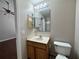 Bathroom featuring a vanity, toilet, mirrored cabinet, and an adjacent bedroom at 1912 Conch Ln, Kissimmee, FL 34759
