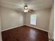 Bedroom with wood flooring, ceiling fan, and a bright window at 1912 Conch Ln, Kissimmee, FL 34759