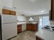 Kitchen featuring tile floors, white appliances, and light wood cabinetry at 1912 Conch Ln, Kissimmee, FL 34759