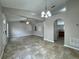 Open-concept living room featuring neutral paint, tile floors, a ceiling fan, and arched doorways at 1912 Conch Ln, Kissimmee, FL 34759