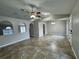 Open-concept living room featuring neutral paint, tile floors, a ceiling fan, and arched doorways at 1912 Conch Ln, Kissimmee, FL 34759