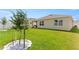 Lush backyard featuring green grass, a covered patio, and mature trees at 1975 Cacutta Way, Kissimmee, FL 34744