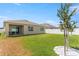 Expansive backyard featuring a covered patio, mature trees, and a white vinyl fence at 1975 Cacutta Way, Kissimmee, FL 34744