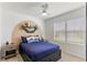 This bedroom features carpeted floors, a ceiling fan, a window and decorative shelving at 1975 Cacutta Way, Kissimmee, FL 34744