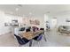 Open-concept dining area flowing to the kitchen, featuring a modern table, black chairs, and bright lighting at 1975 Cacutta Way, Kissimmee, FL 34744