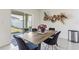 Modern dining area features stylish chairs, an elegant table, and a sliding glass door leading to a backyard at 1975 Cacutta Way, Kissimmee, FL 34744