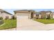 Close-up of a single-Gathering home with a well-manicured lawn and a two-car garage at 1975 Cacutta Way, Kissimmee, FL 34744