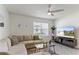 Comfortable living room with a large sectional, ceiling fan, and a view of the neighborhood outside the window at 1975 Cacutta Way, Kissimmee, FL 34744