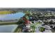Aerial shot of a cozy home by a serene lake, surrounded by lush trees and a bustling highway at 2019 Wintermere Pointe Dr, Winter Garden, FL 34787